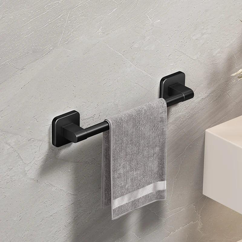 HomesshopUK matte black self-adhesive bathroom towel holder with a grey towel on a grey wall