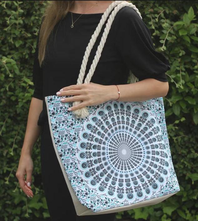 Woman holding a HomesshopUK beach bag with rope handles and a blue mandala pattern.