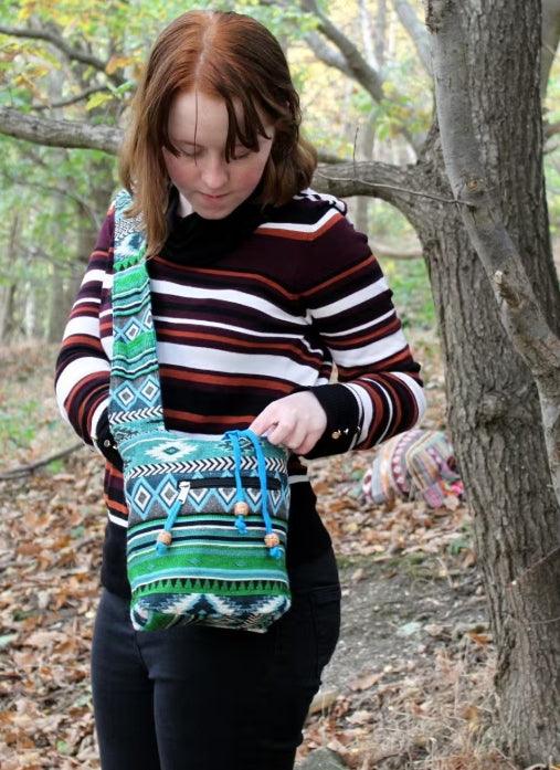 Woman wearing a HomesshopUK colorful jacquard sling bag with geometric patterns.