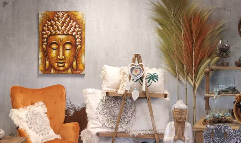 Boho living room decor with Buddha art, orange armchair, and textured white cushions.
