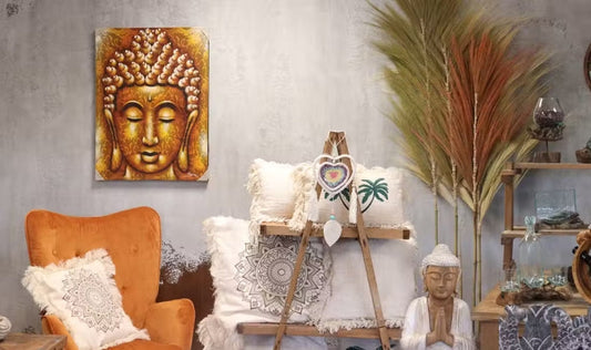 Boho living room decor with Buddha art, orange armchair, and textured white cushions.